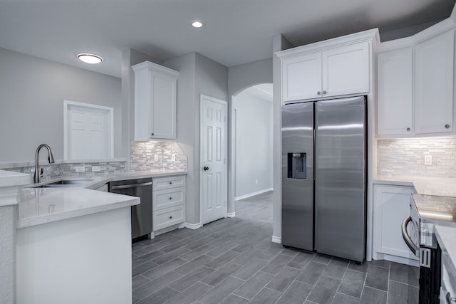 kitchen featuring dark hardwood / wood-style floors, sink, white cabinetry, decorative backsplash, and appliances with stainless steel finishes