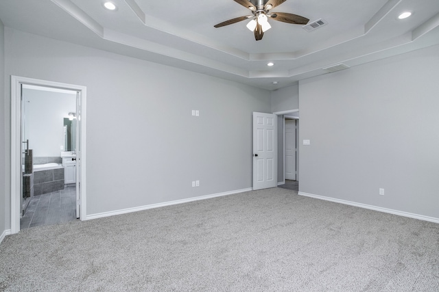 unfurnished room featuring ceiling fan, a raised ceiling, and carpet floors