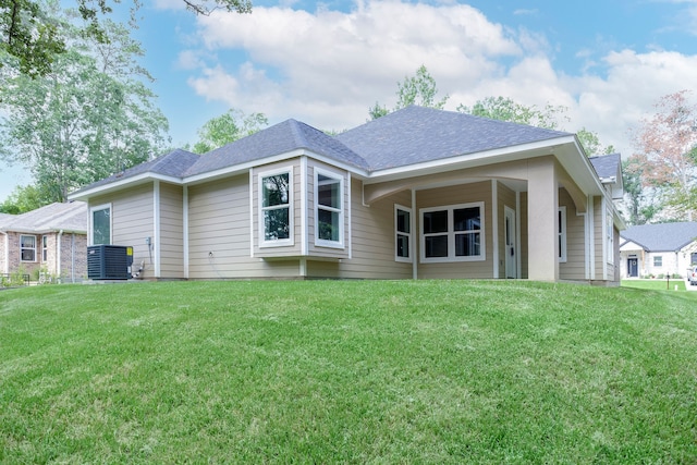 rear view of house with a lawn and central AC unit