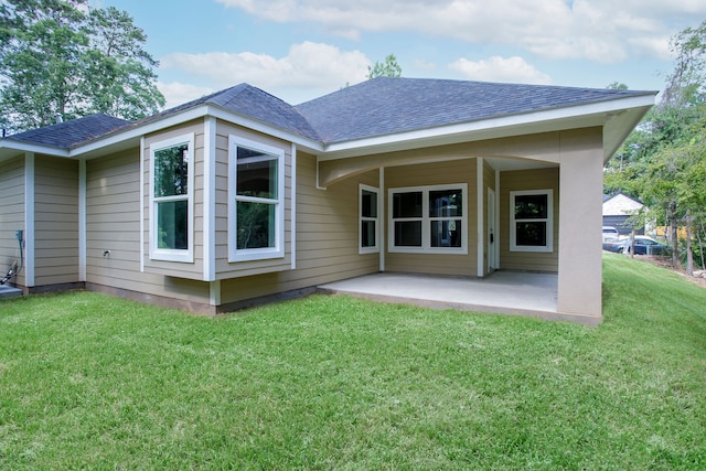 rear view of house featuring a lawn and a patio area