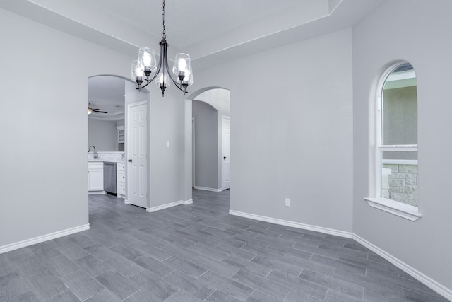 unfurnished dining area featuring ceiling fan with notable chandelier and dark hardwood / wood-style flooring