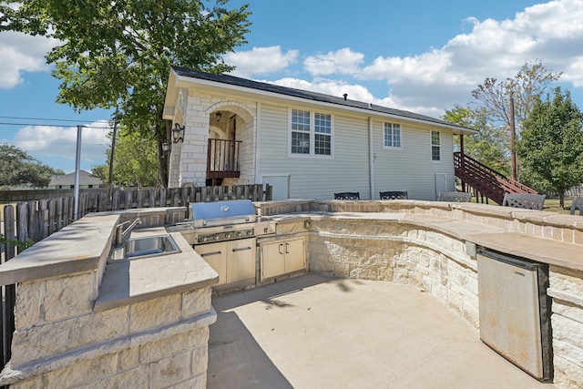 view of patio / terrace with exterior kitchen, a grill, and sink