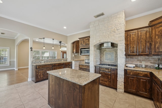 kitchen featuring light stone counters, a center island, and plenty of natural light