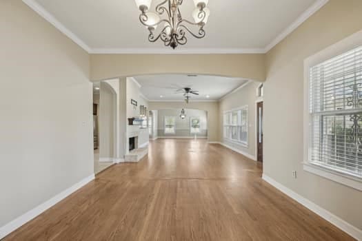 hallway with ornamental molding, a chandelier, and hardwood / wood-style flooring