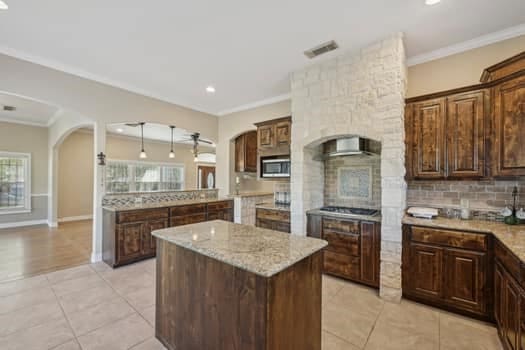 kitchen featuring light stone counters, plenty of natural light, decorative backsplash, and a kitchen island