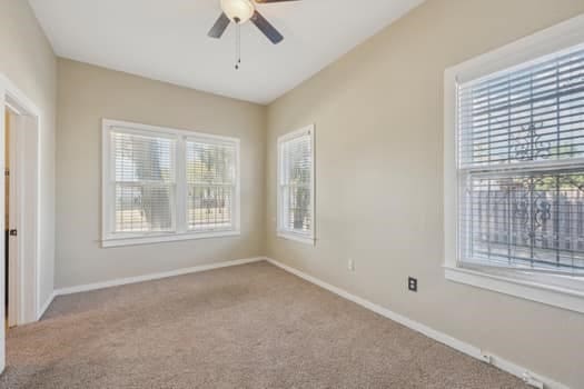 unfurnished room with light carpet, ceiling fan, and plenty of natural light