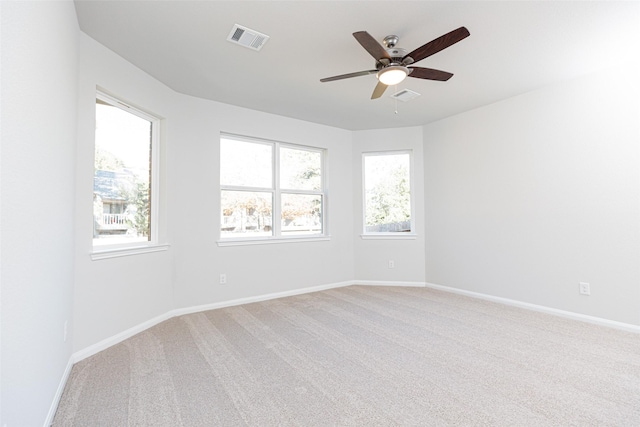 unfurnished room featuring carpet floors, a wealth of natural light, and ceiling fan