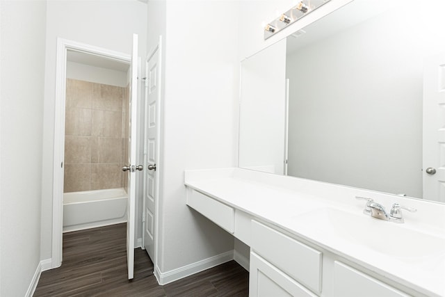 bathroom featuring vanity, wood-type flooring, and tiled shower / bath