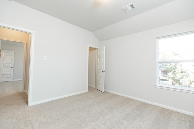 empty room featuring lofted ceiling and light carpet