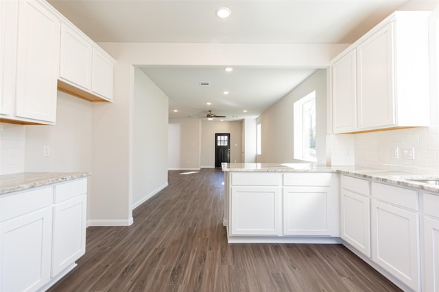 kitchen featuring backsplash, ceiling fan, white cabinets, and dark hardwood / wood-style floors