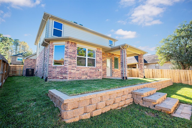 rear view of property featuring a lawn and central AC