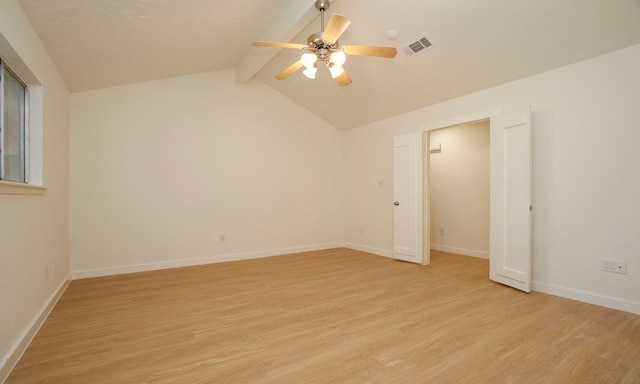 spare room with ceiling fan, light wood-type flooring, and lofted ceiling with beams