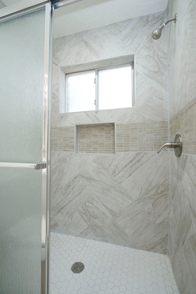 bathroom featuring a shower with shower door