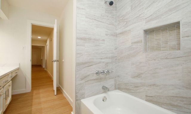 bathroom featuring vanity, tiled shower / bath combo, and hardwood / wood-style flooring