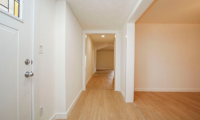 corridor with light hardwood / wood-style floors