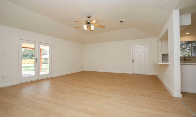 unfurnished living room with ceiling fan, sink, french doors, a textured ceiling, and light hardwood / wood-style floors