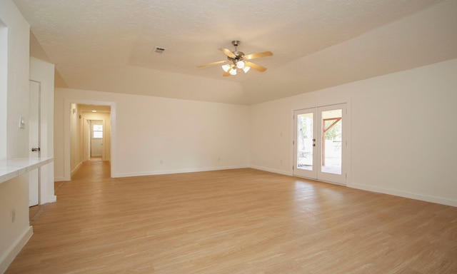 unfurnished room with light wood-type flooring, a textured ceiling, vaulted ceiling, and ceiling fan