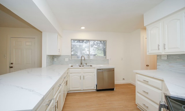 kitchen featuring tasteful backsplash, white cabinets, stainless steel appliances, light wood-type flooring, and sink