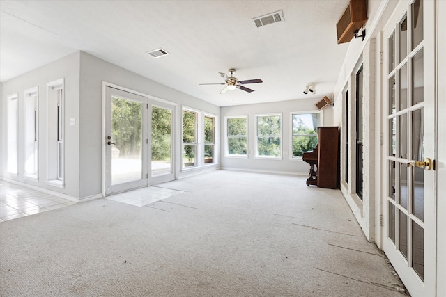 unfurnished sunroom with ceiling fan and a wealth of natural light