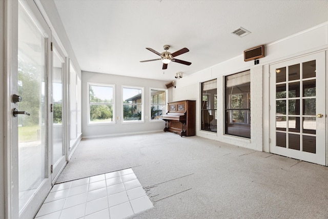 unfurnished sunroom featuring ceiling fan