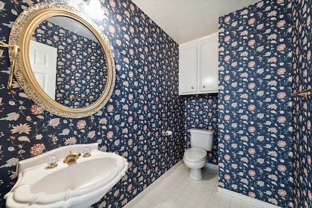 bathroom featuring a textured ceiling, sink, and toilet