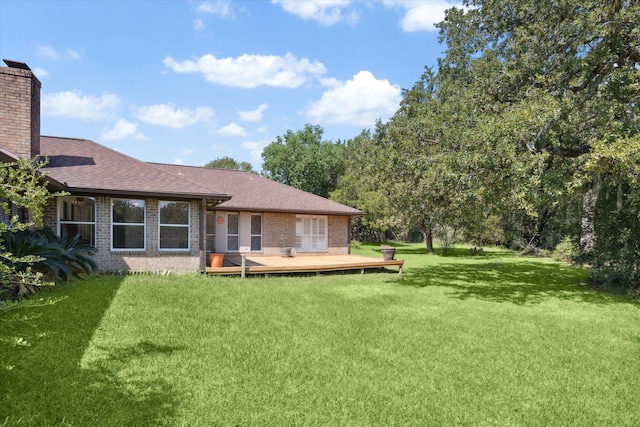 rear view of property featuring a wooden deck and a yard