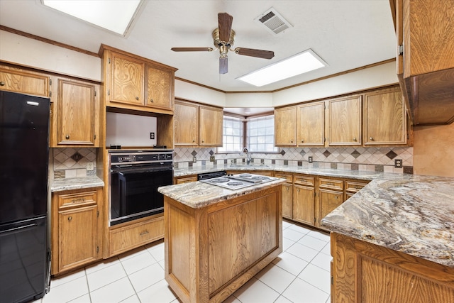 kitchen featuring decorative backsplash, black appliances, ceiling fan, and sink