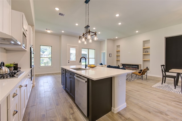 kitchen featuring light wood-type flooring, a chandelier, white cabinets, stainless steel appliances, and decorative light fixtures