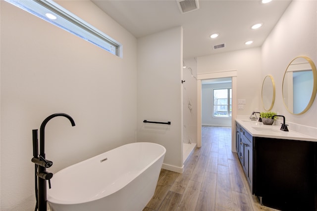 bathroom featuring shower with separate bathtub, vanity, and hardwood / wood-style flooring