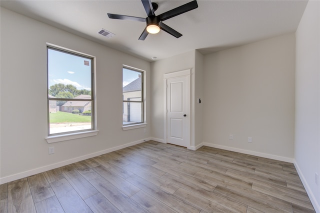 spare room with light hardwood / wood-style flooring, ceiling fan, and a wealth of natural light