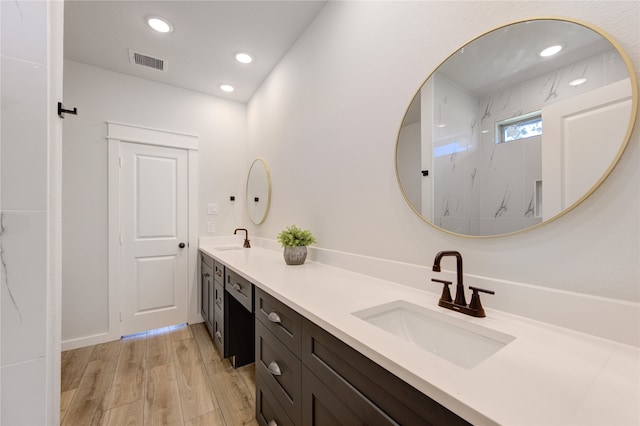 bathroom featuring a shower, vanity, and hardwood / wood-style floors