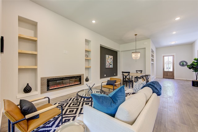 living room with wood-type flooring and built in features