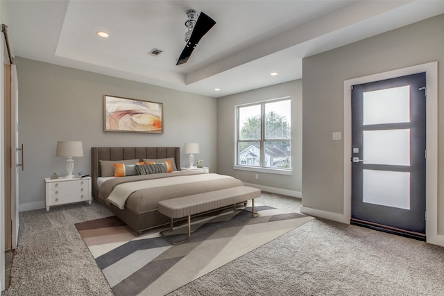 bedroom featuring ceiling fan, light colored carpet, and a tray ceiling