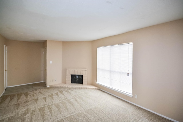 unfurnished living room with a fireplace and carpet