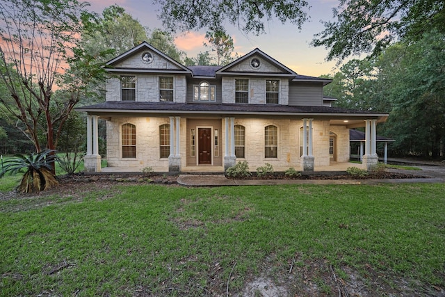 view of front of house featuring covered porch and a yard