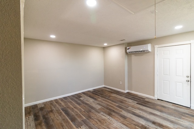 basement with dark hardwood / wood-style floors and a wall mounted air conditioner