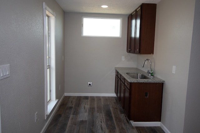 interior space featuring dark hardwood / wood-style flooring, dark brown cabinets, a textured ceiling, and sink