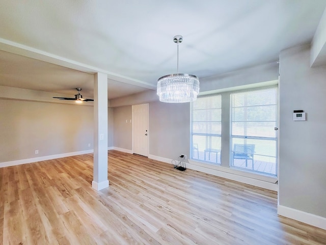 interior space with ceiling fan with notable chandelier and light hardwood / wood-style flooring