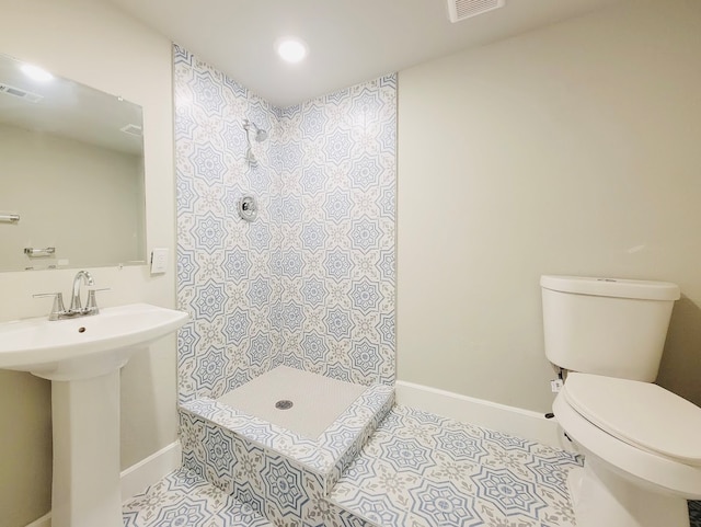 bathroom with a shower, tile patterned flooring, and toilet