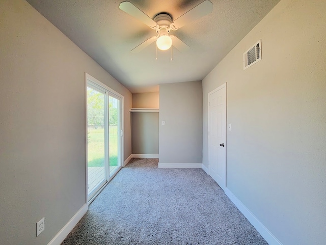 unfurnished room featuring a textured ceiling, light carpet, and ceiling fan