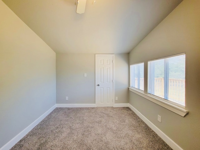 carpeted spare room with lofted ceiling and ceiling fan