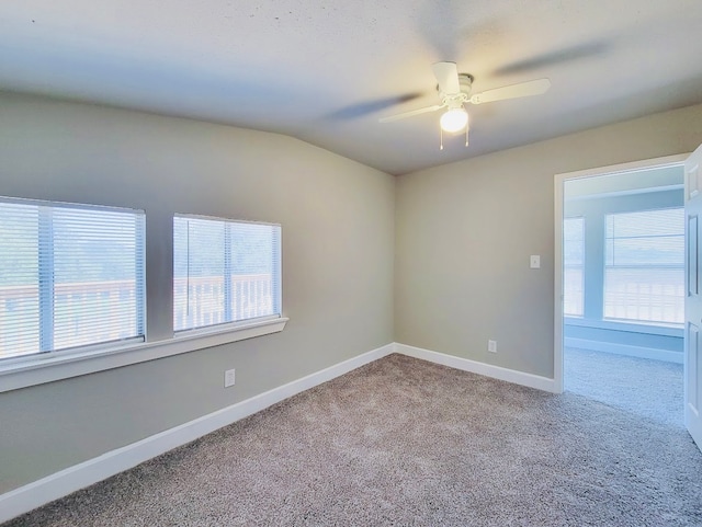 carpeted empty room with vaulted ceiling and ceiling fan