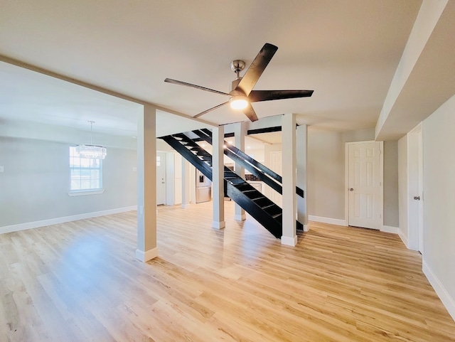 interior space with ceiling fan with notable chandelier and light hardwood / wood-style floors