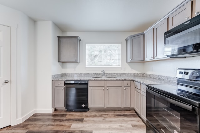 kitchen with gray cabinetry, hardwood / wood-style flooring, sink, and black appliances