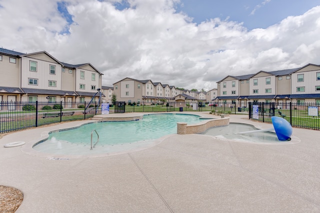 view of swimming pool with pool water feature and a patio