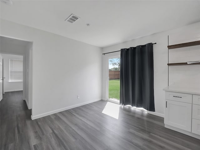 empty room with dark hardwood / wood-style flooring