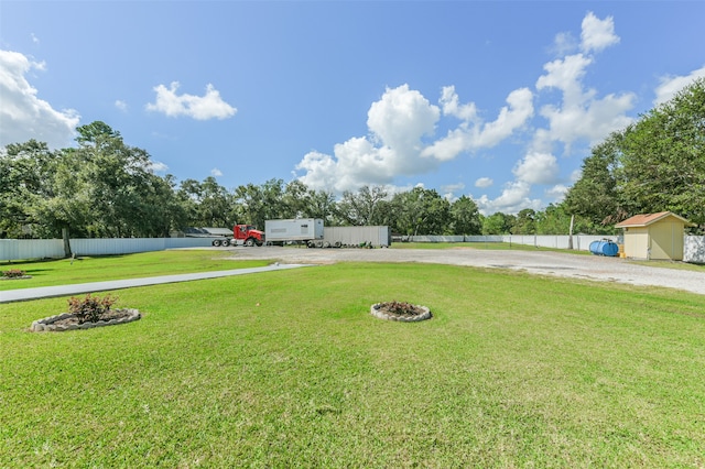 view of yard with a shed and an outdoor fire pit