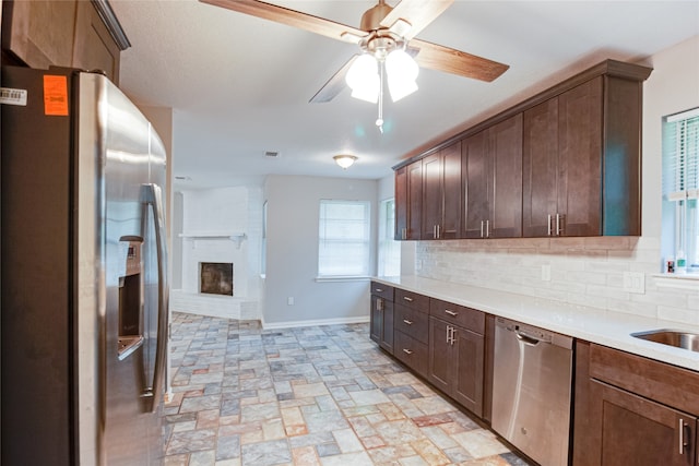 kitchen with ceiling fan, stainless steel appliances, dark brown cabinets, and decorative backsplash