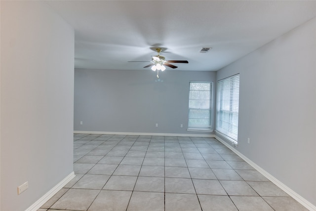 tiled spare room with ceiling fan