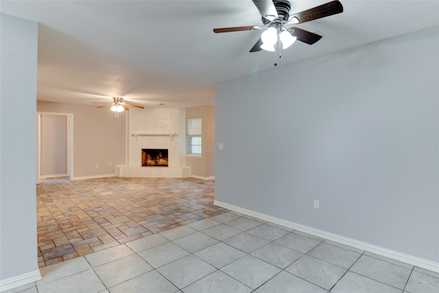 unfurnished living room featuring ceiling fan and a brick fireplace